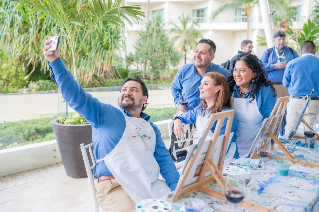 A group taking a photo together beside their painting easels